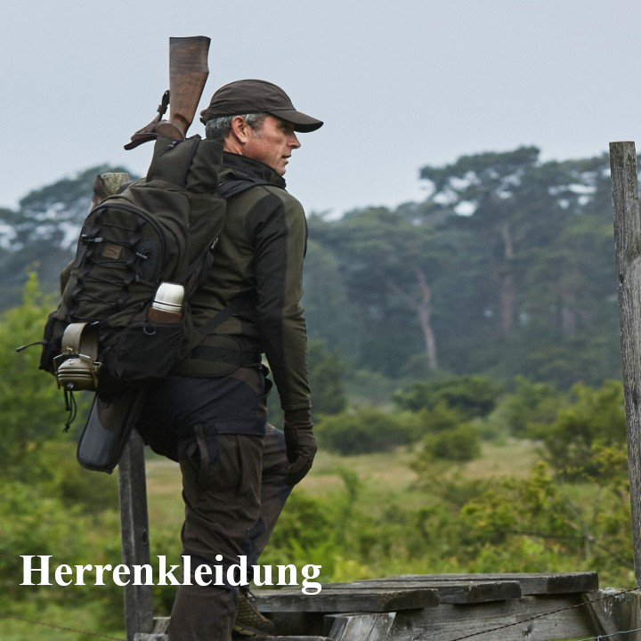 Jäger mit Rucksack und Waffe klettert über einen Zaun
